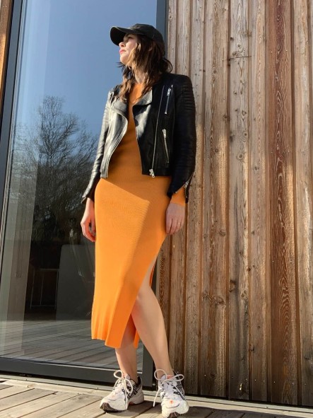 Frida Landbecker i en orange klnning p en altan.