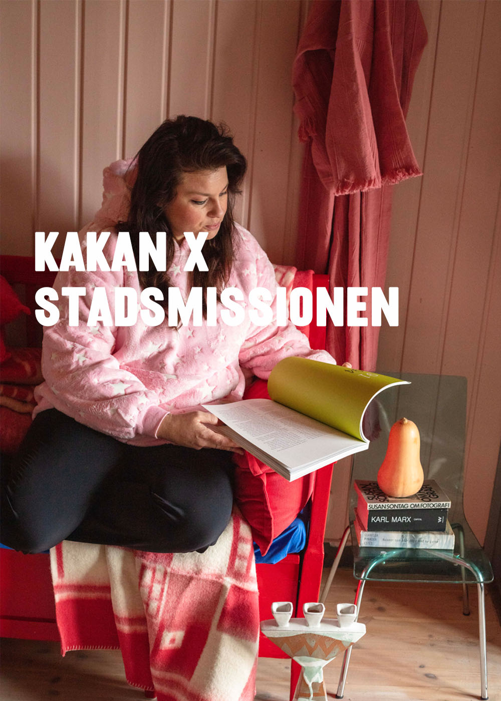 Kakan Hermanson sitter p en soffa och tittar i en tidning. Gr till Kampanj